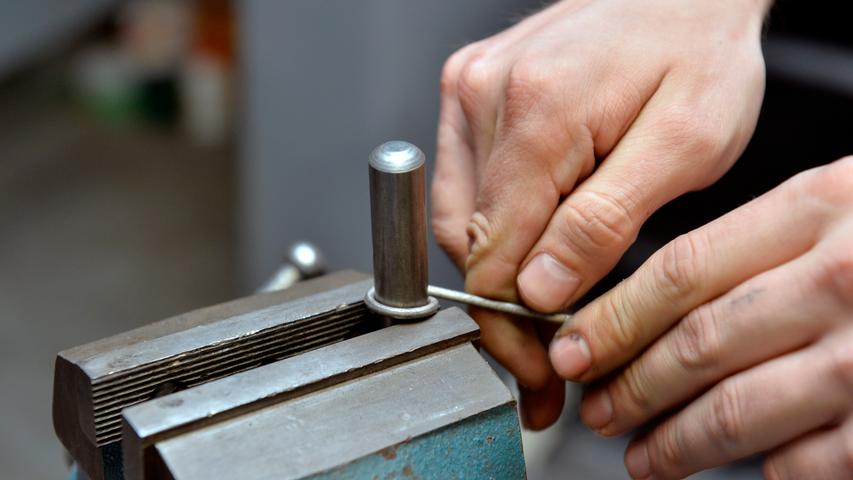 Dann rollt er es um einen Punzen herum, ein längliches Stück Werkzeugstahl, das es in allen Finger-Großen gibt.