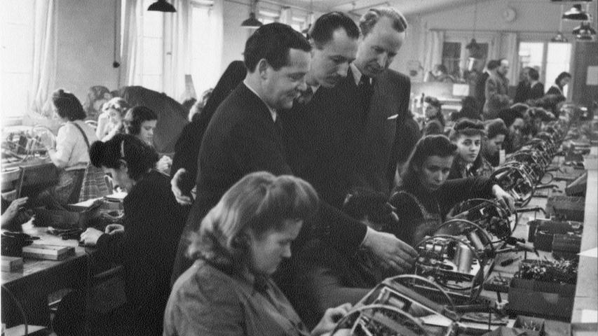 1949: Max Grundig (links, stehend) gibt zwei Jahre nach der Eröffnung der Fertigung an der Fürther Kurgartenstraße seinen ersten Presseempfang.