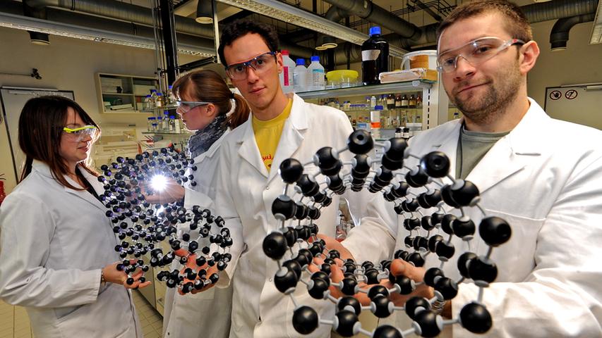 Kathrin Knirsch, Ricarda Schäfer, Mario Marcia und Udo Mundloch mit verschiedenen Molekül-Modellen, Udo Mundloch (rechts) mit einer Kohlenstoff-Nano-Röhre.