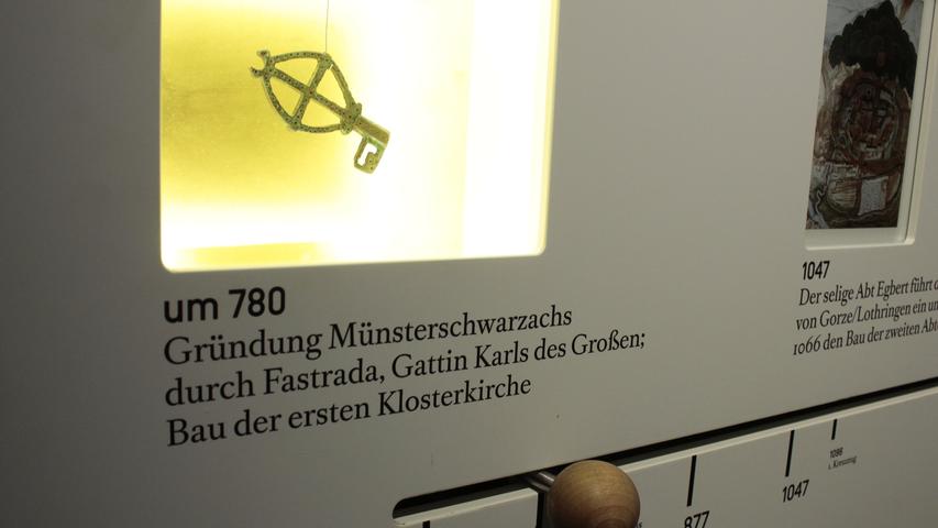 Dieser Schlüssel mit eingearbeitetem Kreuz ist der älteste Gegenstand, der auf dem Abteigelände gefunden wurde. Er soll aus dem 9. Jahrhundert stammen. Im Jahr 780 wurde ein Frauenkloster in Münsterschwarzach gegründet, seit 816 gibt es die Mönchsgemeinschaft.