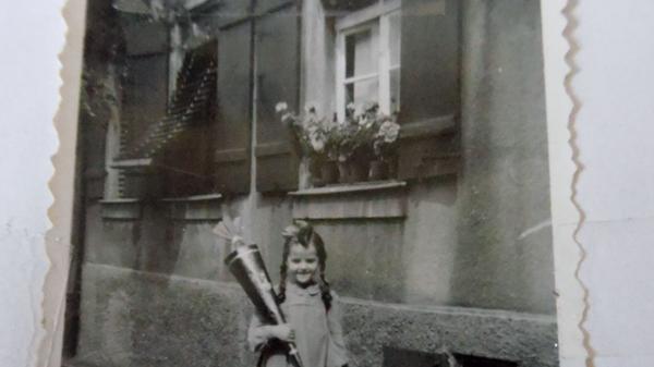 Voller Vorfreude präsentiert Gerlinde Schon (geb. Heidelberger) vor dem Schrödershof ihre Schultüte. Los ging es für sie im Jahr 1950 im Michelschulhaus (Mädchen). "Ich selbst wohnte damals im 'Michala' (Knabenschulhaus) neben dem Hausmeistersehepaar Kneißel. Mein Vater war Lehrer und durfte nach dem Krieg die Wohnung oben im Schulhaus beziehen."