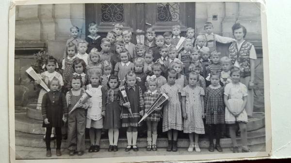 Den großen Tag haben diese Schulinder wohl höchst unterschiedlich empfunden. Manche scheinen sich zu freuen, andere wissen offenbar nicht recht, wie ihnen geschieht. Heidrun Stadelmann aus Ansbach (erste Reihe, Zweite von links) gehört zu den wenigen Kindern, die für das Erinnerungsfoto eine Schultüte präsentieren.
