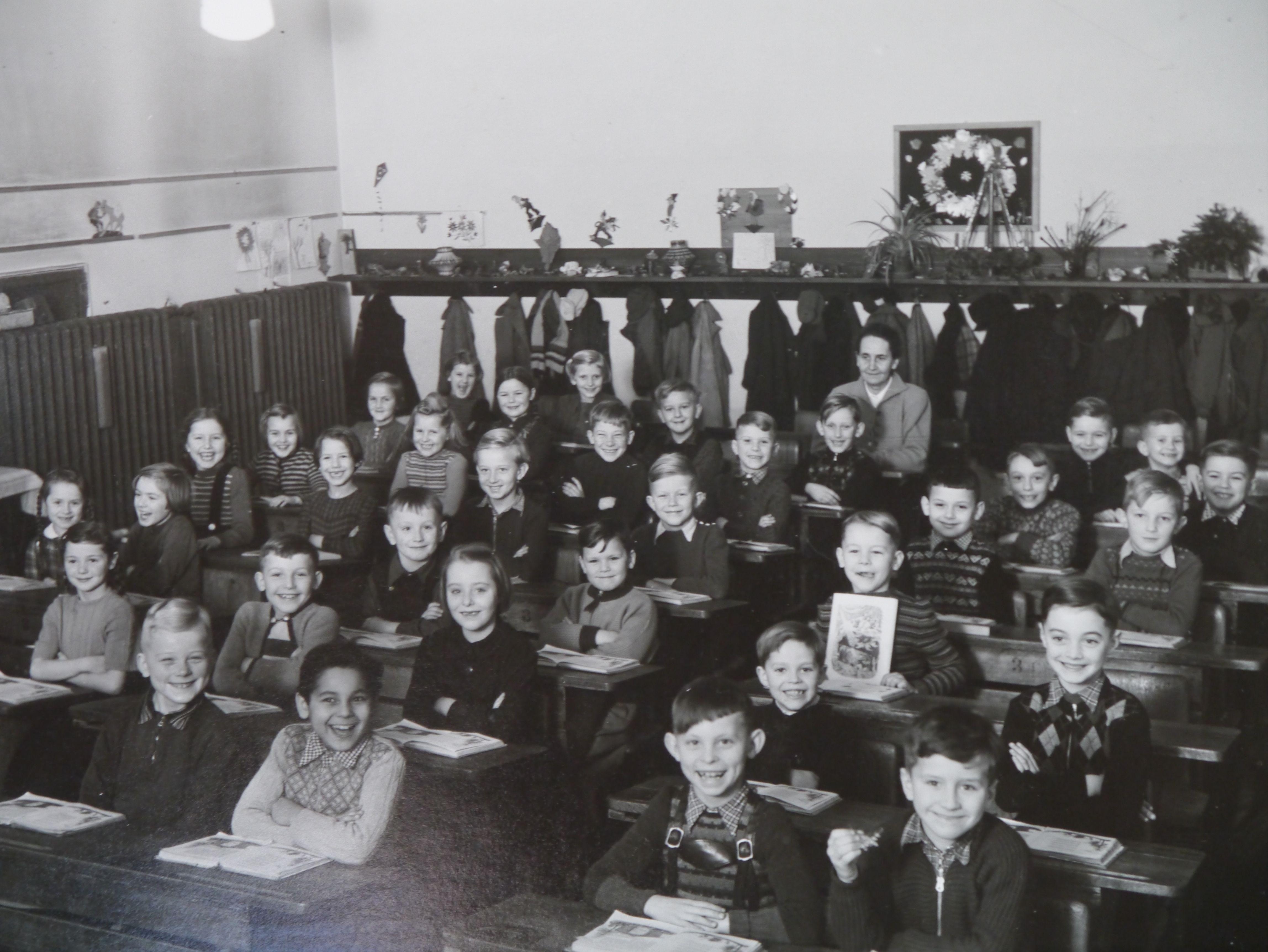 Gerhard Clemenz wurde im September 1953 in der damaligen Prinzregentenschule in Erlangen am Langemarckplatz eingeschult. Ganz hinten im Bild ist seine Lehrerin, "Fräulein Hegewald", zu sehen. "Damals war das ein ganz normaler Tag, nicht vergleichbar mit eventartigen Veranstaltungen heute", sagt Clemenz. "War es besser oder schlechter? Weiß ich nicht so genau, ganz schlecht kann es nicht gewesen sein, wie die fröhlichen Gesichter zeigen."