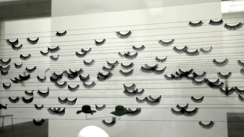 "Schwarm" heißt das exquiste Vitrinenwerk von Andreas Oehlert. Hunderte von künstlichen Wimpern hat er darin aufgefädelt und die Fäden mit kleinen, schwarz glänzenen Onyxsteinen beschwert, die an Tränen erinnern.