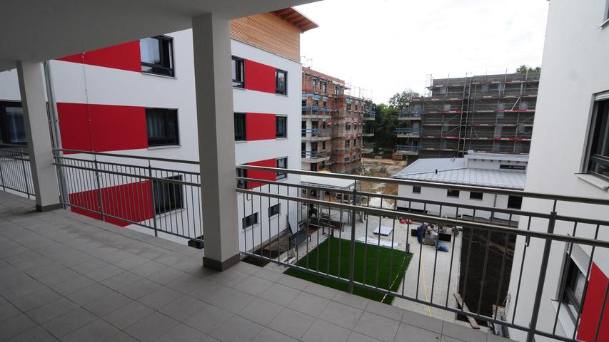 Dazu gehört ein großer Balkon, auf dem die Bewohner das Treiben im Innenhof oder rund um die Neubauten beobachten können.