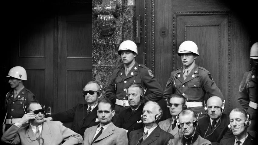 Fritz Sauckel (hinten rechts) war seit 1927 Gauleiter in Thüringen und die letzten drei Jahre des Krieges "Generalbevollmächtigter für den Arbeitseinsatz in Deutschland". Er wurde wegen Verbrechen gegen das Kriegsrecht und Verbrechen gegen die Menschlichkeit zum Tod durch den Strang verurteilt. Sauckel sagte während des Prozesses immer wieder Halbwahrheiten und zeigte keine Reue. Besondere Aufmerksamkeit widmeten die Nürnberger Nachrichten während der Prozesse dem Mann aus Haßfurt in Unterfranken: "Er hat die größte Armee aller Zeiten aufgestellt und befehligt, die vielen Millionen Sklaven, die das Material für Hitlers Krieg herstellen mussten (...). Nicht nur als Arbeitsdiktator, sondern auch als Industrieführer spielte Sauckel eine wichtige Rolle in der deutschen Kriegsproduktion. Er wurde 1935 zum Leiter der Suhler Waffenwerke bestellt, denen er alle anderen thüringischen Waffenfabriken angegliedert hat (...). Nachdem er sich in diesem Wirkungskreis als brutaler Ausbeuter der Arbeiter bewährt hatte, erhielt er 1942 seine Ernennung zum Generalbevollmächtigten für den Arbeitseinsatz." Fritz Sauckel (hinten rechts) war seit 1927 Gauleiter in Thüringen und die letzten drei Jahre des Krieges "Generalbevollmächtigter für den Arbeitseinsatz in Deutschland". Er wurde wegen Verbrechen gegen das Kriegsrecht und Verbrechen gegen die Menschlichkeit zum Tod durch den Strang verurteilt. Sauckel sagte während des Prozesses immer wieder Halbwahrheiten und zeigte keine Reue. Besondere Aufmerksamkeit widmeten die Nürnberger Nachrichten während der Prozesse dem Mann aus Haßfurt in Unterfranken: "Er hat die größte Armee aller Zeiten aufgestellt und befehligt, die vielen Millionen Sklaven, die das Material für Hitlers Krieg herstellen mussten (...). Nicht nur als Arbeitsdiktator, sondern auch als Industrieführer spielte Sauckel eine wichtige Rolle in der deutschen Kriegsproduktion. Er wurde 1935 zum Leiter der Suhler Waffenwerke bestellt, denen er alle anderen thüringischen Waffenfabriken angegliedert hat (...). Nachdem er sich in diesem Wirkungskreis als brutaler Ausbeuter der Arbeiter bewährt hatte, erhielt er 1942 seine Ernennung zum Generalbevollmächtigten für den Arbeitseinsatz."