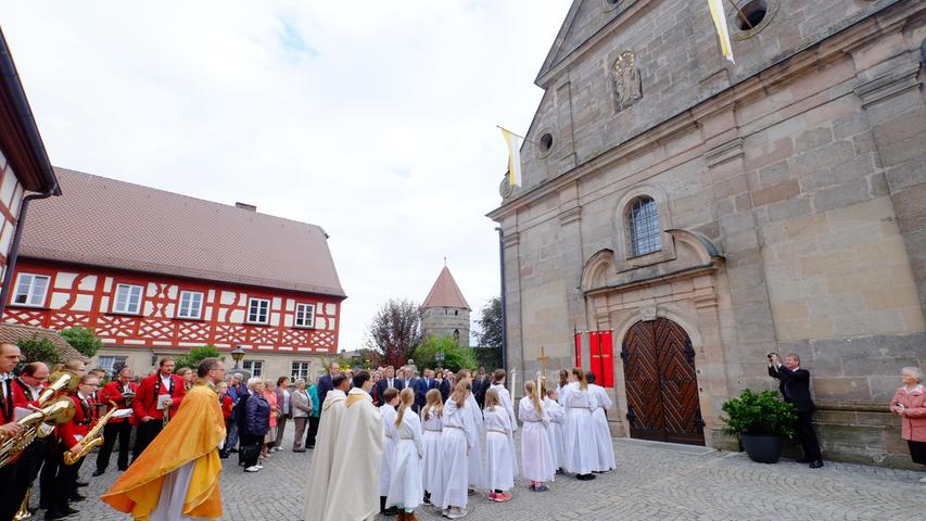 Pfarrer Lars Rebhan wartet mit den Ministranten, bis die Kirchentür geöffnet wird.