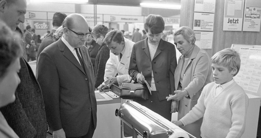 An den Verkaufs- und Informationsständen - 310 Aussteller sind da - gab es über das Wochenende viele Besucher. An einem Bügelautomaten (links) zeigt ein Bub, wie leicht er zu bedienen ist.  Hier geht es zum Artikel: Buntes Allerlei lockt die Massen vom 31. Oktober 1966.