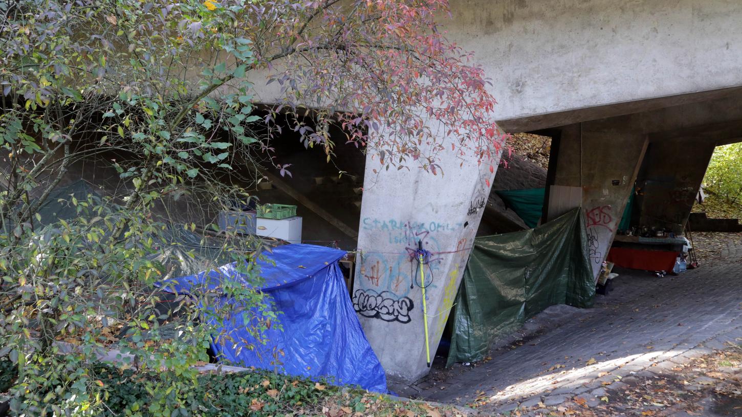 Die Obdachlosen schützen sich unter der Franz-Josef-Strauß-Brücke mit einer Plane vor der kalten Zugluft.