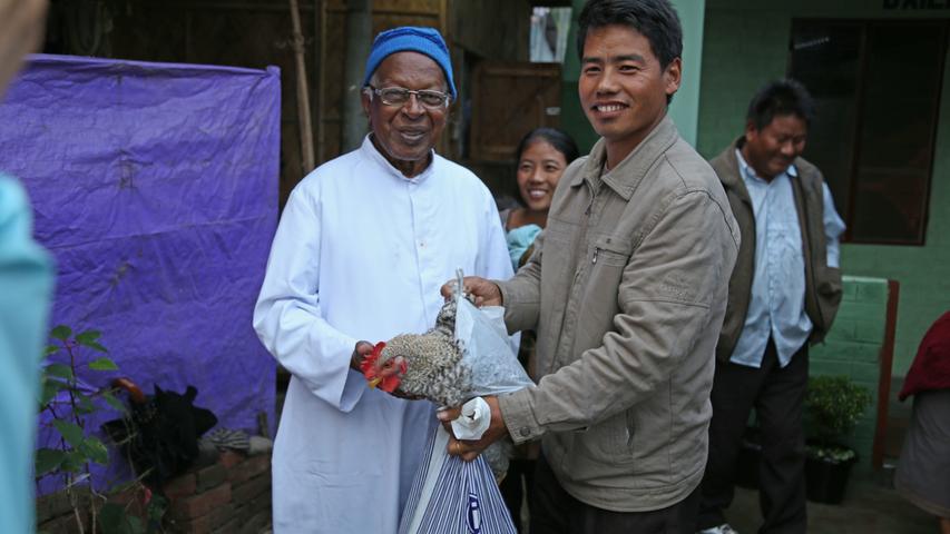 Die Familie bedankt sich bei Pater Josef für die Organisation des Hausbaus mit einem lebenden Huhn.