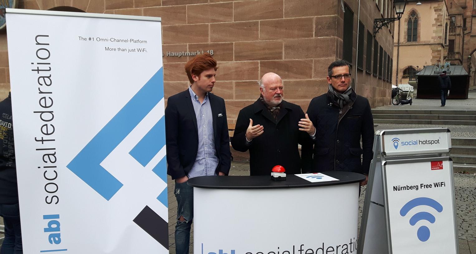 Personal- und Organisationsreferent Wolfgang Köhler (Mitte), Wirtschaftsreferent Michael Fraas (rechts) und Benjamin Akinci, Geschäftsführer der abl social federation GmbH, präsentieren den Start des neuen WLAN-Angebots am Hauptmarkt.