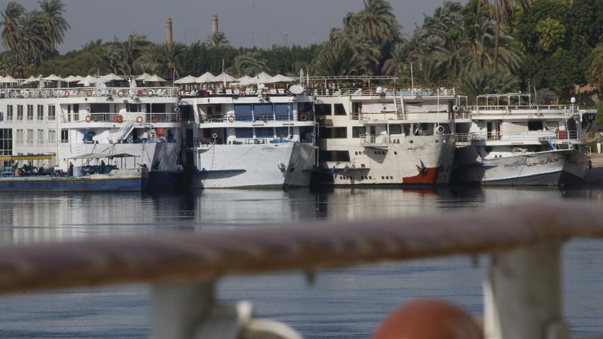 Da liegen sie dicht an dicht, die typischen Nilkreuzfahrtschiffe. Wer genau hinsieht, bemerkt aber: Nur die beiden linken mit den aufgespannten Sonnenschirmen werden derzeit tatsächlich benutzt. Die beiden, die näher am Ufer liegen, warten dagegen auf bessere Zeiten.