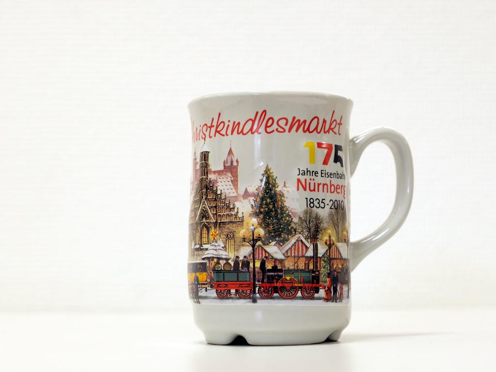 Neben Motiven wie der Nürnberger Altstadt und des Christkindlesmarkts, ziert der "Adler" die Tasse aus dem Jahr 2010. Der Anlass hierfür lässt sich ebenfalls auf der Tasse erahnen. Denn in diesem Jahr feierten wir "175 Jahre Eisenbahn Nürnberg". Der Adler dampfte am 7. Dezember 1835 erstmalig auf der sechs Kilometer langen Strecke zwischen Nürnberg und Fürth. Neben Motiven wie der Nürnberger Altstadt und des Christkindlesmarkts, ziert der "Adler" die Tasse aus dem Jahr 2010. Der Anlass hierfür lässt sich ebenfalls auf der Tasse erahnen. Denn in diesem Jahr feierten wir "175 Jahre Eisenbahn Nürnberg". Der Adler dampfte am 7. Dezember 1835 erstmalig auf der sechs Kilometer langen Strecke zwischen Nürnberg und Fürth.