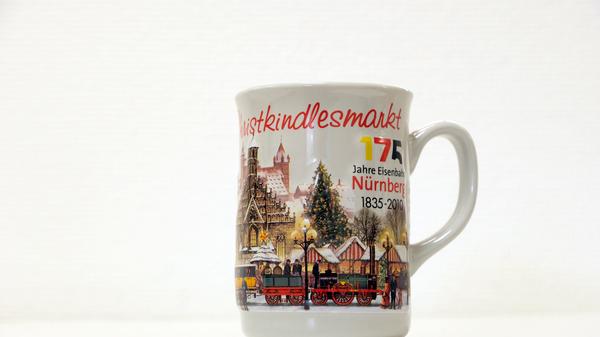 Neben Motiven wie der Nürnberger Altstadt und des Christkindlesmarkts, ziert der "Adler" die Tasse aus dem Jahr 2010. Der Anlass hierfür lässt sich ebenfalls auf der Tasse erahnen. Denn in diesem Jahr feierten wir "175 Jahre Eisenbahn Nürnberg". Der Adler dampfte am 7. Dezember 1835 erstmalig auf der sechs Kilometer langen Strecke zwischen Nürnberg und Fürth.