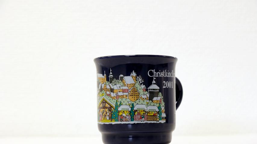 Im Vorjahr zierten die Tasse weniger Farben. Auf einer ebenfalls dunkelblauen Tasse waren etwas mehr Buden, die Burg und viele andere Gebäude zu sehen. Auch eine Krippe war auf der Tasse abgebildet. 