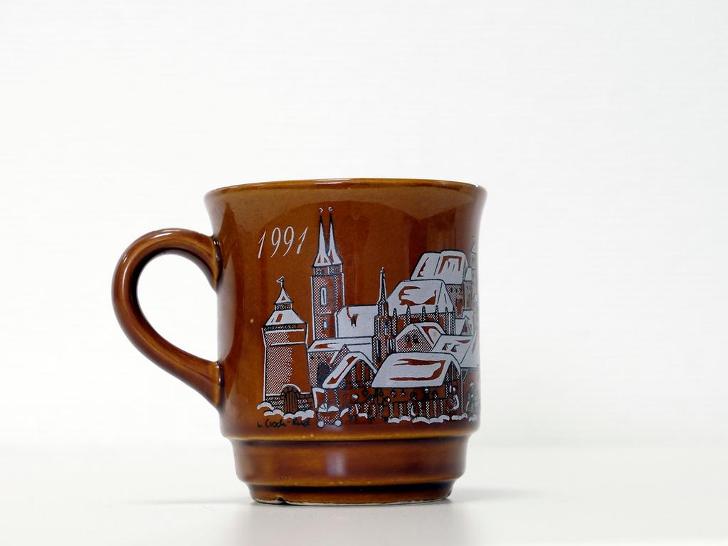 Ganz ohne Widmund oder Portrait eines Dichters, Uhrmachers oder eines anderen bekannten Nürnbergers war die Tasse des Jahres 1991 gestaltet. Auf der braunen Grundierung waren ganz klassisch Buden sowie Nürnbergs bekannteste Gebäude und Kirchen abgebildet. Ganz ohne Widmund oder Portrait eines Dichters, Uhrmachers oder eines anderen bekannten Nürnbergers war die Tasse des Jahres 1991 gestaltet. Auf der braunen Grundierung waren ganz klassisch Buden sowie Nürnbergs bekannteste Gebäude und Kirchen abgebildet.