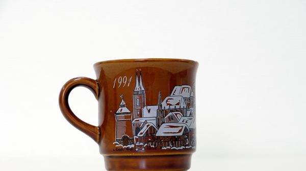 Ganz ohne Widmund oder Portrait eines Dichters, Uhrmachers oder eines anderen bekannten Nürnbergers war die Tasse des Jahres 1991 gestaltet. Auf der braunen Grundierung waren ganz klassisch Buden sowie Nürnbergs bekannteste Gebäude und Kirchen abgebildet.