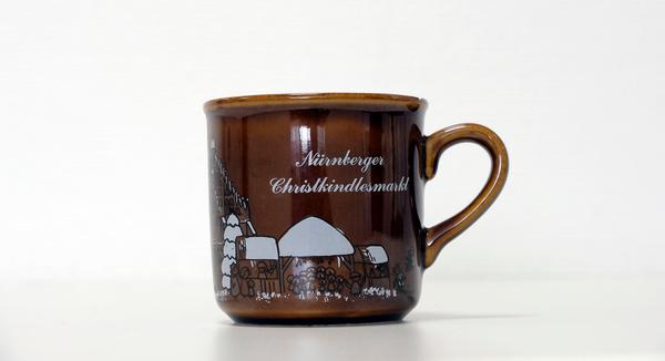 Die erste Christkindlesmarkt-Tasse, die es gab: Ganz schlicht, mit wenigen Buden, einer Krippe, der Frauenkirche und dem Schönen Brunnen war diese gestaltet. Anders als in den darauffolgenden Jahren war nicht einmal die Jahreszahl abgedruckt worden. Nach kurzer Zeit sollen von den Exemplaren bereits so viele in Umlauf gewesen sein, dass sogar noch Ersatztassen angeschafft werden mussten.