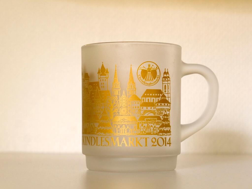 Ein Blick auf die Tasse des Jahres 2014 zeigt einen deutlichen optischen Unterschied. Anders als in den vergangenen Jahren war die Tasse milchig-glasig und mit goldenen Details geschmückt. Besonders die Architektur Nürnbergs war darauf zu sehen. So etwa die Lorenzkirche und die Kaiserburg.  Ein Blick auf die Tasse des Jahres 2014 zeigt einen deutlichen optischen Unterschied. Anders als in den vergangenen Jahren war die Tasse milchig-glasig und mit goldenen Details geschmückt. Besonders die Architektur Nürnbergs war darauf zu sehen. So etwa die Lorenzkirche und die Kaiserburg.