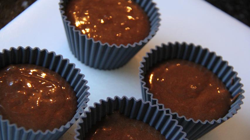 Der Teig aus geschmolzener Bitterschokolade, Butter, Olivenöl, Eiern, Mehl, Zucker und Rosmarin kommt in kleine Muffin-Förmchen und dann für sechs Minuten in den Ofen.