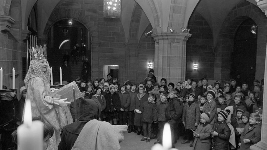 Von Kerzenlicht umstrahlt, spricht das Christkind seine Begrüßungsworte. In der Ehrenhalle des Rathauses am Wolff'schen Bau stehen die Buben und Mädchen, ihre Gutscheine für die 'G'schenkla' in der Hand, und bestaunen die schöne Himmelsbotin.Hier geht es zum Artikel vom 13. Dezember 1966: "Weihnachtsfreude für die Kleinen"