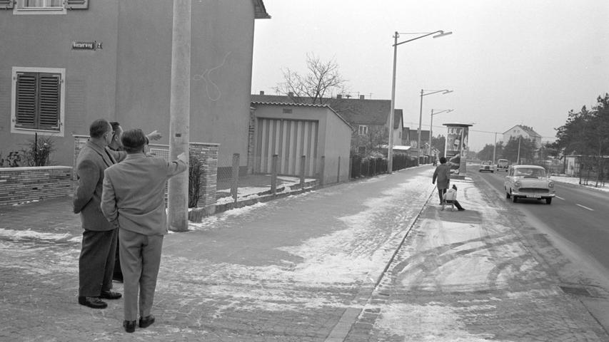 Ein Teil der Zollhausstraße mit dem Gehsteig und den Parkflächen. Erregt diskutieren diese drei Neulandsiedler, dass sie etwas bezahlen sollen, von dem sie, wie sie meinen, keinen Nutzen haben.  Hier geht es zum Artikel vom 29. Dezember 1966: Böse Überraschung