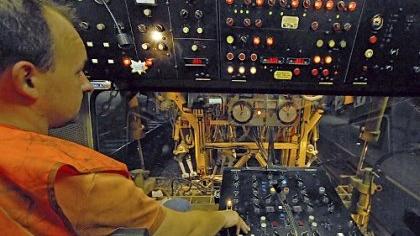 Schienenbaumaschinist Endré Graff aus Bochum sitzt im Cockpit der Stopfmaschine, die die Schienen millimetergenau ausrichtet und den Schotter darunter festrüttelt (links). Weiter vorn auf der Baustelle am Hauptbahnhof sind die Gleisbauer unterwegs und fräsen überstehendes Metall ab, nachdem zwei Schienenstränge verschweißt wurden. Im Hintergrund der Sicherheitsdienst. Schienenbaumaschinist Endré Graff aus Bochum sitzt im Cockpit der Stopfmaschine, die die Schienen millimetergenau ausrichtet und den Schotter darunter festrüttelt (links). Weiter vorn auf der Baustelle am Hauptbahnhof sind die Gleisbauer unterwegs und fräsen überstehendes Metall ab, nachdem zwei Schienenstränge verschweißt wurden. Im Hintergrund der Sicherheitsdienst.