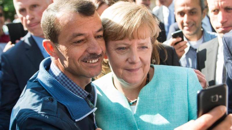 Für dieses Foto mit einem Flüchtling erntete Kanzlerin Angela Merkel Kritik.