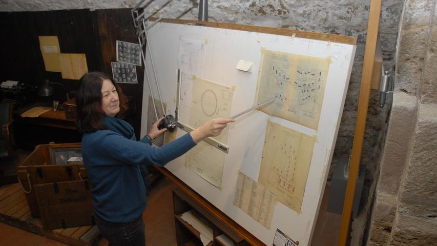 Museumsleiterin Irene Lederer an einem großen Reißbrett aus den Anfangszeiten. Ob auf ihm das erste käfiggeführte Nadellager gezeichnet wurde?