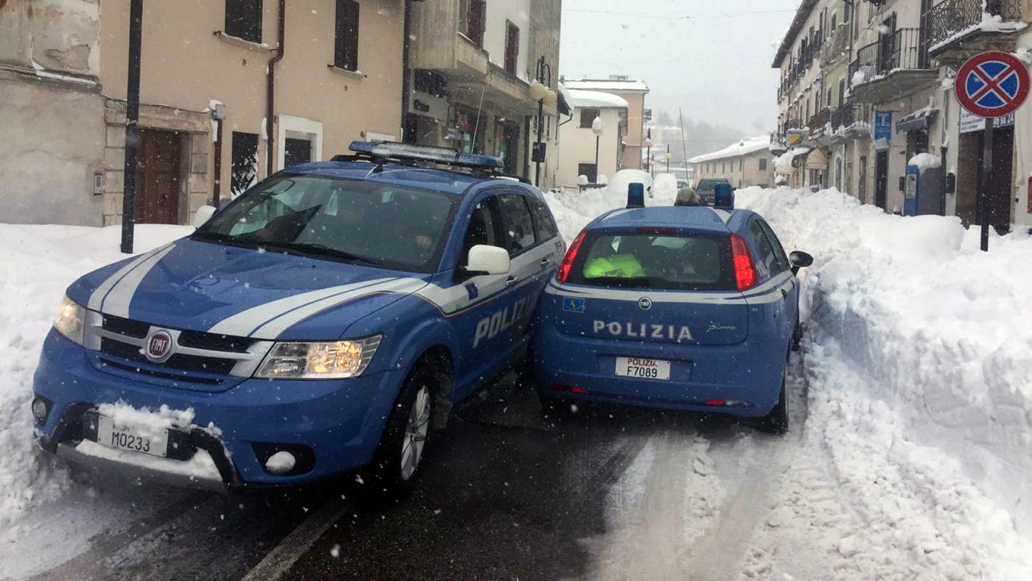 Zwei Polizeiautos stehen auf einer Straße in Monereale (Italien). Heftige Erdstöße, innerhalb weniger Stunden, haben erneut die Region in Mittelitalien getroffen. Ein Schneechaos erschwerte allerdings die Hilfe.