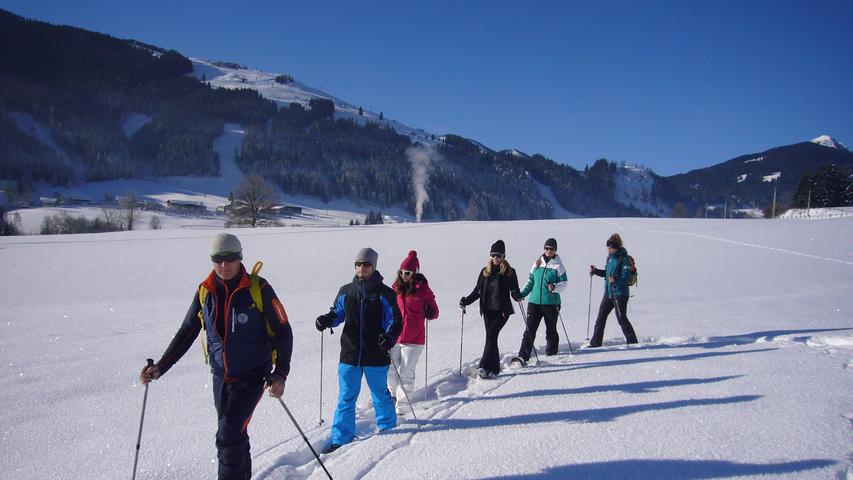 Auf der Sonnenseite des Pinzgaus: Von Leogang aus kann man mit Schneeschuhen über tiefverschneite Wiesen und durch Wälder zu Almen und Aussichtspunkten wandern.