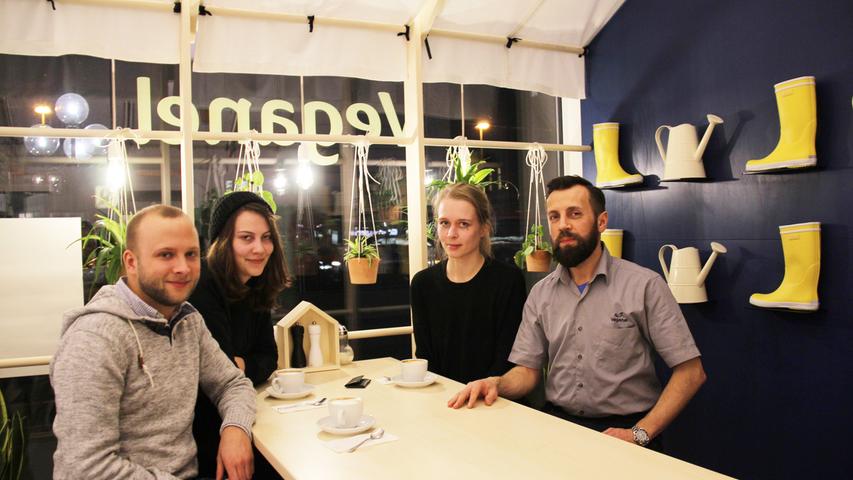 Weiße Gießkannen und gelbe Gummistiefel hängen abwechselnd und in Reihe an einer dunkelblauen Wand. Schon zum zweiten Mal sind Jonas (27), Inga (26) und Jasmin (26, v. links) ins "Veganel" in Nürnberg-Gostenhof gekommen – und sind damit sozusagen Stammgäste, zumindest angehende. Denn das kleine, gemütliche Restaurant in der Fürther Straße 43, das unter anderem Soja-Burger, Quiche und vegane Pizzen auf der Speisekarte hat, ist erst Anfang Januar, vor gut fünf Wochen, eröffnet worden. "Wir drei sind alle Vegetarier", erklärt Jasmin, "und wir mögen auch vegane Gerichte". Die Nürnberger sind nicht nur wiedergekommen, weil es ihnen schmeckt. Vor allem das stilvolle und zugleich ungewöhnliche Flair im Veganel gefällt ihnen. "Die Gießkannen und Gummistiefel an der Wand erinnern an den Garten und daran, dass wir unser Essen aus der Erde beziehen", sagt Ewald David Edelberg (rechts), Inhaber und Küchenchef des "Veganel". Das Besondere: Alles in seinem Lokal ist "zu 100 Prozent ökologisch": von den regionalen Lebensmitteln, über die Verpackungen und den Strom, bis hin zu den Hockern und Tischen aus Holz. "Leute, die sich gesund ernähren, achten auch auf Nachhaltigkeit. Das muss alles stimmig sein." Weiße Gießkannen und gelbe Gummistiefel hängen abwechselnd und in Reihe an einer dunkelblauen Wand. Schon zum zweiten Mal sind Jonas (27), Inga (26) und Jasmin (26, v. links) ins "Veganel" in Nürnberg-Gostenhof gekommen – und sind damit sozusagen Stammgäste, zumindest angehende. Denn das kleine, gemütliche Restaurant in der Fürther Straße 43, das unter anderem Soja-Burger, Quiche und vegane Pizzen auf der Speisekarte hat, ist erst Anfang Januar, vor gut fünf Wochen, eröffnet worden. "Wir drei sind alle Vegetarier", erklärt Jasmin, "und wir mögen auch vegane Gerichte". Die Nürnberger sind nicht nur wiedergekommen, weil es ihnen schmeckt. Vor allem das stilvolle und zugleich ungewöhnliche Flair im Veganel gefällt ihnen. "Die Gießkannen und Gummistiefel an der Wand erinnern an den Garten und daran, dass wir unser Essen aus der Erde beziehen", sagt Ewald David Edelberg (rechts), Inhaber und Küchenchef des "Veganel". Das Besondere: Alles in seinem Lokal ist "zu 100 Prozent ökologisch": von den regionalen Lebensmitteln, über die Verpackungen und den Strom, bis hin zu den Hockern und Tischen aus Holz. "Leute, die sich gesund ernähren, achten auch auf Nachhaltigkeit. Das muss alles stimmig sein."