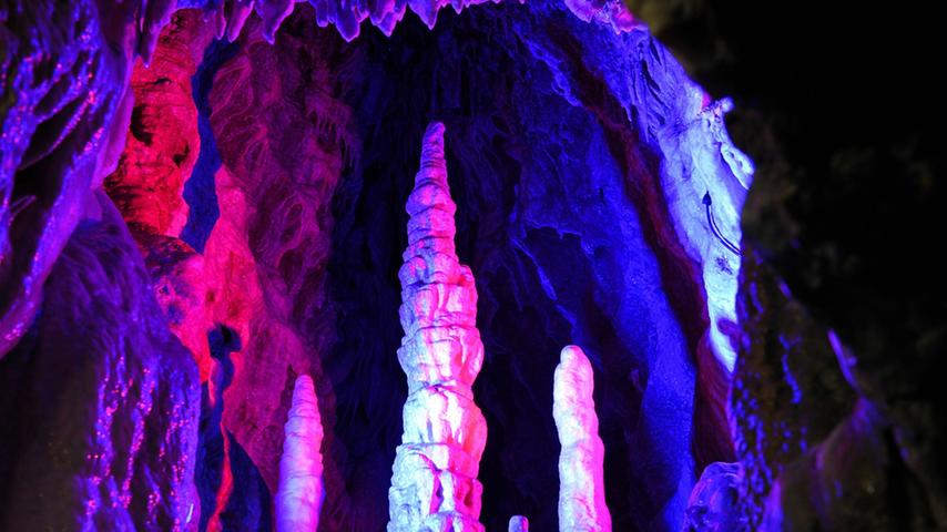 Die Tropfsteinformation "Kreuzigungsgruppe" in der Teufelshöhle wird in mystischen Farben angestrahlt. 