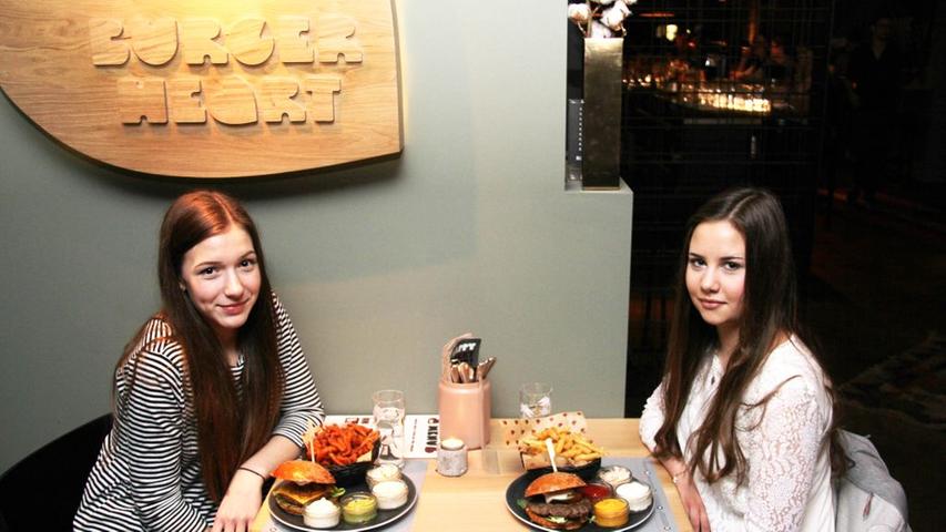 Burger, Cocktails und mehr: Das "Burgerheart" ist noch frisch in Bamberg und schon stillt es den Hunger der Oberfranken nach selbstgemachten Burgern und Dips. Yola Welz (16, links) und Jana Reich (16, rechts) sind seit der Eröffnung im Dezember letzten Jahres "schon zum zweiten Mal da" und das nicht ohne Grund: "Hier kann man einfach super Burger essen gehen, vor allem mit und ohne Fleisch". Neben Burgern und Dips treibt es die Bamberger auch wegen der selbstgemachten Limonaden und frisch geschüttelten Cocktails in das Restaurant in der Langen Straße 38. "Anfangs haben die uns die Bude eingerannt, mittlerweile hat sich der Betrieb eingependelt", resümiert Betriebsleiter Brian Ellison über die ersten Wochen und Monate. Moderne Einrichtung und ein lockeres Ambiente sorgen mit Burgern wie dem "Matterhorn" oder dem "Chuck Norris" für ein atmosphärisches und kulinarisch rundes Erlebnis.