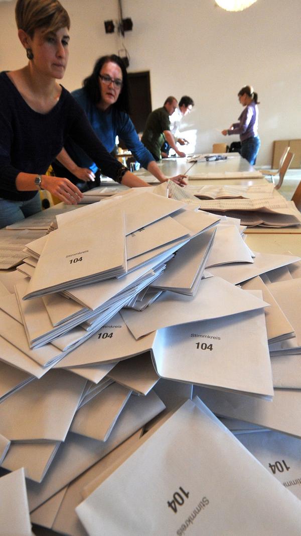 Wenn um Punkt 18 Uhr die Wahllokale schließen, werden dort die Urnen geöffnet und die Stimmzettel ausgezählt. Ehrenamtliche Helfer notieren anschließend händisch die Ergebnisse. Die Ehrenamtlichen bekommen dafür ein sogenanntes "Erfrischungsgeld": Bei der Bundestagswahl 2017 betrug dieses, wie schon in der Vergangenheit, 21 Euro. Grundsätzlich können die Gemeinden übrigens jeden Wahlberechtigten für die Aufgabe verpflichten. Bei der letzten Bundestagswahl 2017 waren rund 650.000 freiwillige Helfer am Wahlabend im Einsatz.
