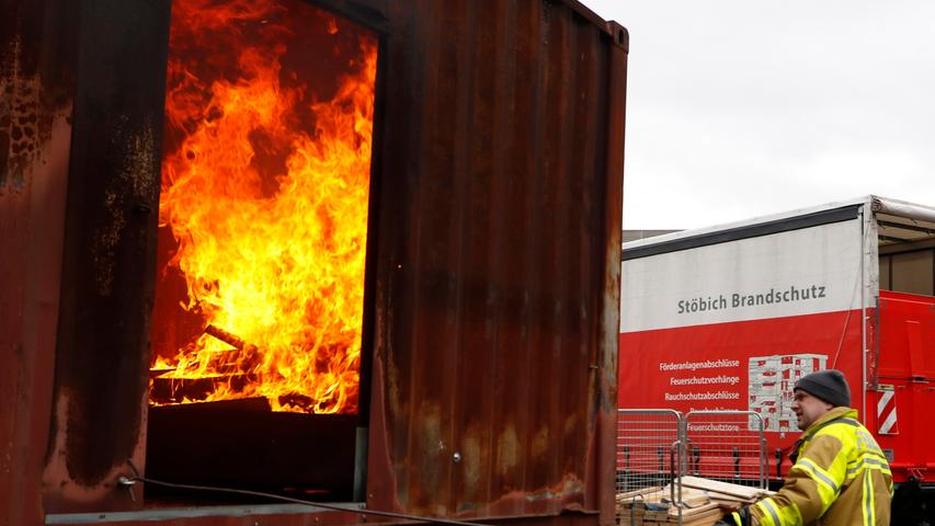 Für die Vorführung der Brandschutztextilien wird in einem Container kräftig eingeschürt.