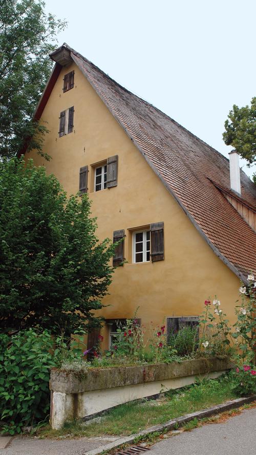 Als die Eigentümerin das 1843/44 am Ortsrand von Deckersberg errichtete repräsentative Hopfenbauern-Wohnstallhaus 1998 erworben hatte, befand sich das Haus in dramatisch ruinösem Zustand. 50 Jahre hatte es leer gestanden. Bis in die 1970er Jahre wurden Kühe im Erdgeschoss gehalten. Über etwa 15 Jahre hinweg und mit einem Höchstmaß an Eigenleistung hat die Eigentümerin das gesamte Gebäude instandgesetzt und es dabei – von modernen Zutaten weitgehend verschont – nahezu in den Originalzustand verbracht. Das große Interesse der Eigentümerin an denkmalgerechtem Materialeinsatz und überlieferten Handwerkstechniken sowie ihr einfühlsames Vorgehen merkt man dem Haus an vielen Stellen an,zum Beispiel an Details wie dem hölzernen Paketkasten an der Traufseite oder der perfekt aufgearbeiteten Haustüre. Dank ihres außerordentlichen Engagements konnte ein regionaltypisches Gebäude für die Zukunft erhalten und in einen attraktiven und authentischen Zustand versetzt werden.