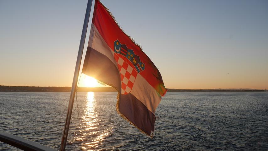 Morgendämmerung: Die ersten Sonnenstrahlen erleuchten die kroatische Flagge der Andela Lora.
