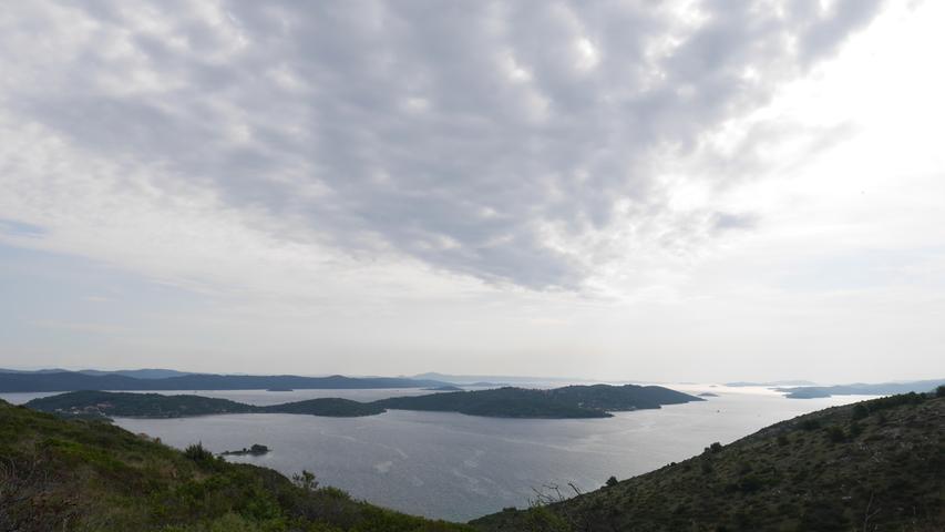 Auf eine tolle Insellandschaft mit attraktiven Wolken sieht man auf Dugo Otok hier mit Blick auf die kroatische Küste.