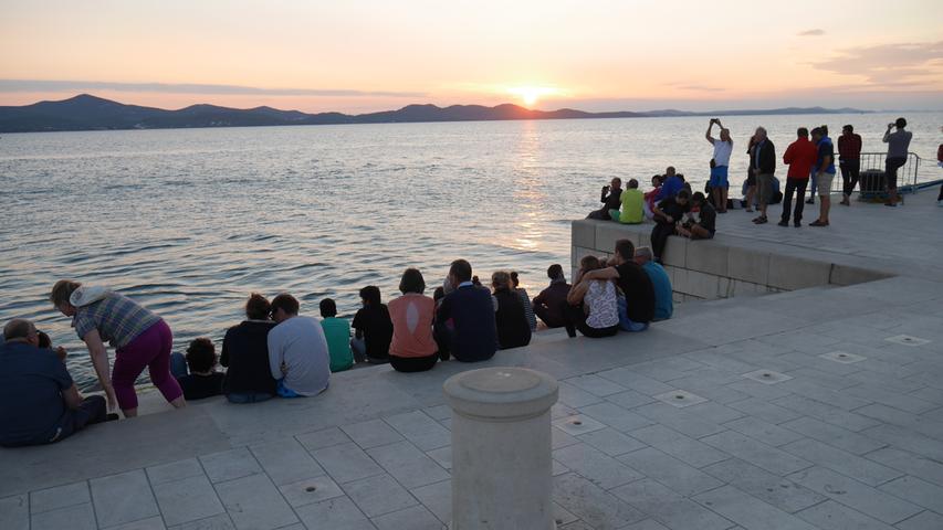 Sonnenuntergang in Zadar, während die seit 2005 bestehende Meeresorgel im Rhythmus der Brandung tief grummelnd erklingt.