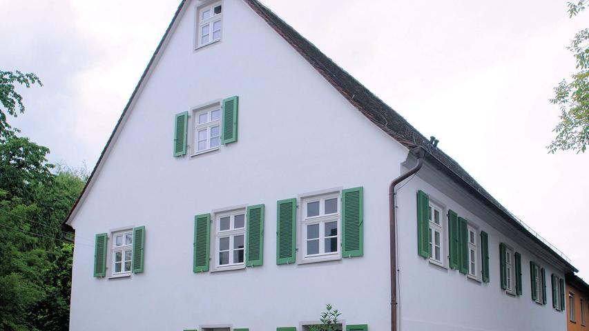 Die ehemalige Kaserne gehört ebenfalls zum Gelände des einstmaligen Dominikanerinnenklosters, das die wechselvolle Geschichte Frauenaurachs komprimiert widerspiegelt. Das hier ab 1616 gebaute Schloss diente unter anderem als provisorische Unterbringung für hugenottische Glaubensflüchtlinge. Mit dem Ausbau des nahen Erlangens zur markgräflichen Residenz verlor das Frauenauracher Schloss an Bedeutung und wurde 1710 bis 1780 als Kaserne genutzt, später als Getreidemagazin. Durch den 1862 schließlich durchgeführten Abriss ging allerdings nicht der gesamte, ursprünglich zur Gesamtanlage gehörende Bestand verloren. Bei dem heute zu Wohnzwecken genutzten Gebäude Brauhofgasse Nr. 8, ein zweigeschossiger Satteldachbau mit Fachwerkobergeschoss, handelt es sich um einen Teil der ehemaligen Kaserne. Das, was an historischer Bausubstanz überliefert war, wurde mit äußerster Sorgfalt überarbeitet. Schäden am Dach und insbesondere an den Treppen wurden fachgerecht behoben. Der behutsame Umgang mit dem noch erhaltenen Bestand zeichnet insgesamt auch diese vorbildliche Gesamtsanierung aus.