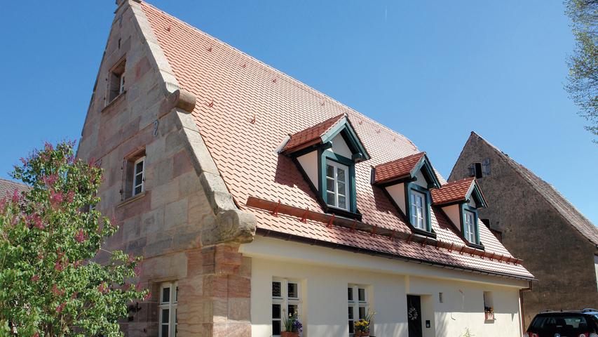 Das ehemalige Wohnstallhaus aus der Mitte des 18. Jahrhunderts (1745/46) im heute zu Nürnberg gehörenden Dorf Neunhof bei Kraftshof wurde nach jahrelangem Leerstand umfangreich saniert. Der teilverputzte, eingeschossige Sandsteinquaderbau mit Satteldach und auskragender Traufe zeichnet sich vor allem durch seinen Voluten-Ziergiebel an der Westfassade aus, eine charakteristische Besonderheit, die in dieser Form nur im Umland von Nürnberg zu finden ist. Die zur ebenfalls denkmalgeschützten Scheune (bez. 1725) gerichtete Ostfassade wurde in Fachwerk errichtet. Auf Grundlage der umfangreich überlieferten Bausubstanz und ausführlicher Befunde wurde das Bauernhaus zu einem Wohnhaus umgebaut. Der in ursprünglicher Konstruktion erhaltene Dachstuhl wurde fachgerecht instand gesetzt, die bauzeitlichen Grundrissstrukturen wurden beibehalten. Zur Nutzung und Belichtung des ehemaligen Stallbereichs, dem zukünftigen Wohnzimmer, hat man bewusst ein modernes Bindeglied mit dunkel beschichteten Metallfenstern implementiert. Als anschaulicher Verweis auf die Vergangenheit dienen die aufgearbeitete Bohlenbalkendecke und die sichtbar gebliebenen, zahlreichen geritzten und verzierten Strohlehmgefache der Fachwerkwände. Der Bezirk Mittelfranken würdigt die Sanierung als "hervorragendes Beispiel für die Umnutzung eines historischen Bauernhauses zu einem komfortablen Wohnhaus", die zeitgenössisch und gleichzeitig denkmalgerecht erfolgt sei.