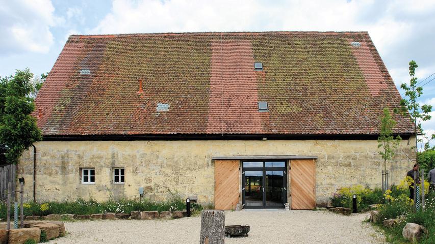 Zwischen Ammerndorf, Neuses und Weinzierlein liegt an der Bibert die erstmals 1464 erwähnte, heute Roßtal zugeordnete Kernmühle. Das Ensemble zieht sich am Fluß entlang und besteht aus einem Mühlengebäude (bez. 1676, abgebrannt 1916, anschließend erneuert), einem Altsitzhaus aus der Mitte des 18. Jahrhunderts, einem Stall und weiteren Kleinbauten sowie aus einer Scheune. Dieser eingeschossige, verputzte Sandsteinquaderbau mit Satteldach ist auf 1849 datiert. Sein Zwerchhaus an der Südostseite wurde erst im 20. Jahrhundert angebaut. Mit der Verpachtung der landwirtschaftlichen Flächen 2011 verlor die Scheune ihre ursprüngliche Funktion. Vorrausschauend hatte die Eigentümerfamilie, in deren Besitz sich das gesamte Anwesen seit 1906 befindet, bereits ein sinnvolles Konzept zur Umnutzung der meisten Wirtschaftsgebäude entwickelt. Die Änderungspläne wurden schrittweise realisiert. Ein Stall war schon 2004 zu einem Seminarhaus umgebaut worden. In der Scheune sollte ein großzügiger Veranstaltungsraum untergebracht werden. Weil ihr Bauzustand vergleichsweise gut war, blieb der Aufwand bei der hierfür nötigen Sanierung überschaubar. Die Arbeiten wurden größtenteils in Eigenleistung erbracht. Ihr charakteristisches Erscheinungsbild hat die Scheune dabei behalten. Dazu gehören vor allem die großen Scheunentore an den Längsseiten, die wenigen Fensteröffnungen und die große Dachfläche, die nicht neu gedeckt werden musste. Der Grundriss wurde nicht verändert. Die dabei verwendeten Materialien fügen sich gut den Bestand ein, bestehende Einbauten hat man durch Gerätschaften aus dem 1966 eingestellten Mühlenbetrieb ergänzt. Notwendige bauliche Änderungen – etwa für Heizung und Geländer – beschränkten sich auf ein Minimum. Dank moderater Eingriffe blieb die Scheune als Zeugnis ländlichen Arbeitens erhalten und ihre ursprüngliche Bestimmung bewusst ablesbar. Die "Event-Scheune" wird jetzt mit großem Erfolg betrieben. Das ist Beleg für die Zukunftsfähigkeit und Durchführbarkeit eines durchdachten Konzepts, mit dem die engagierten Eigentümer den Strukturwandel als Chance begriffen haben.