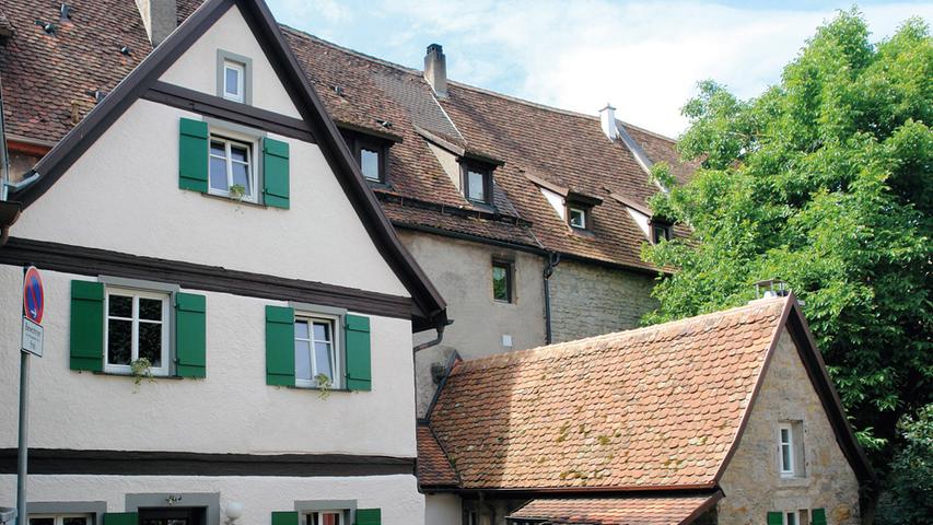 Der zweigeschossige, verputzte Satteldachbau in der Klosterweth 1 ist ein ehemaliges Nebengebäude, das im Kern wohl aus dem 16./17. Jahrhundert stammt. Wie das kleinere, sandsteinerne Schwesterhäuschen zu seiner Rechten ist auch der Ständerbau rückwärtig an ein ehemaliges Ökonomiegebäude des Dominikanerinnenklosters von Rothenburg o.d.T. angebaut. Die heute als Garten genutzte Fläche diente, wie der Straßenname besagt, als Weed (oder Weth) des Klosters, eine als künstlicher Teich angelegte Viehtränke. Nach einem Eigentümerwechsel wurde der vernachlässigte Komplex 2014 grundlegend saniert und im Inneren modernen Wohnansprüchen angepasst. Mit einem hohen Grad an Eigenleistung haben die Eigentümer bei beiden Häuschen das Tragwerk ertüchtigt, bevor die Dächer unter Verwendung historischer Biberschwanzziegel neu eingedeckt wurden. Das Fachwerkhäuschen erhielt einen neuen Fassadenanstrich sowie denkmalgerechte Holzfenster mit passenden Läden. Auch die Fassade des Sandsteinbaus wurde nach ihrer Aufarbeitung mit neuen Fenstern versehen. Im Inneren wurde der historische Bestand schonend aufgearbeitet. Im Einzelnen hat man die Fachwerkbalken freigelegt und restauriert, die originale Holztreppe aufgearbeitet sowie stellenweise die rückwärtige Klostermauer freigelegt und geschickt in den Wohnbereich integriert. Die Eigentümer achteten streng darauf, die passende Naturmaterialien Schilfdämmung und Lehmputz zu verwenden. Eine neue Wandflächenheizung hat den Vorteil, dass die Wohnräume optisch nicht durch Heizkörper gestört werden. Im schmalen Verbindungsbau zwischen den beiden Einzelgebäuden wurde ein Fenster zur zweiten Haustüre erweitert, wodurch sich eine völlig neue Wegeführung ergab. Von diesem zentralen Punkt aus kann der Wohnkomplex nun nach links und rechts erschlossen werden. Dem Besucher präsentiert sich jetzt ein historischer Bau, der durch seine vorbildliche Sanierung deutlich gewonnen hat.