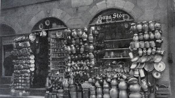 Der Laden in der Hans-Sachs-Gasse verkaufte früher Töpferwaren. In der Nacht des 3. Oktober 1944 zerstörte eine Bombe das Gebäude in der Hans-Sachs-Gasse 5. Tote und Verletzte gab es glücklicherweise nicht, nur Hunderttausende Scherben und einen Nachttopf, der erstaunlicherweise heil geblieben war. Weil niemand in Kriegszeiten ein Haus wieder aufbauen wollte, blieb der zerstörte Töpferladen eine Ruine. Doch das blieb nicht so.
