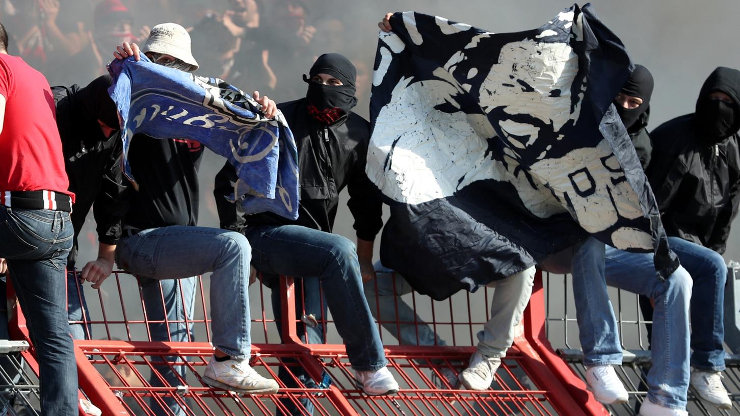 Vermummte Clubfans präsentierten in Karlsruhe geklaute Fahnen des Gegners. Vermummte Clubfans präsentierten in Karlsruhe geklaute Fahnen des Gegners.