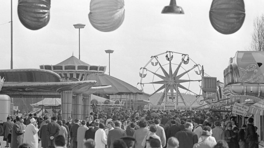 Dichtes Gedränge beim Stelldichein auf dem Platz des harmlosen Vergnügens: bunte Ballons grüßen schon an der Eingangspforte, und im Hintergrund lädt das Riesenrad zu einem 'Dreh-dich-Ausflug' ein. Amüsier- und Schleckerbuden warten nun auf die vielen Kunden. Hier geht es zum Artikel vom 28. März 1967: Trubel und Spaß auf der Festwiese