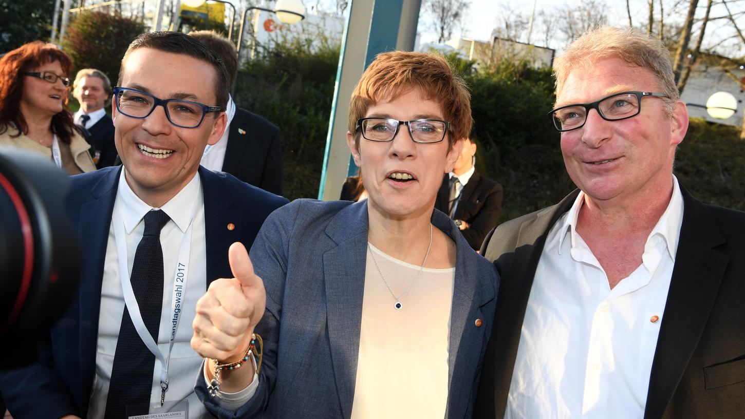 Ministerpräsidentin Annegret Kramp-Karrenbauer und ihr Mann Helmut (rechts) freuen sich über den klaren Sieg der CDU im Saarland. Auch Roland Theis, Landtagsabgeordneter der CDU, hat gut lachen.