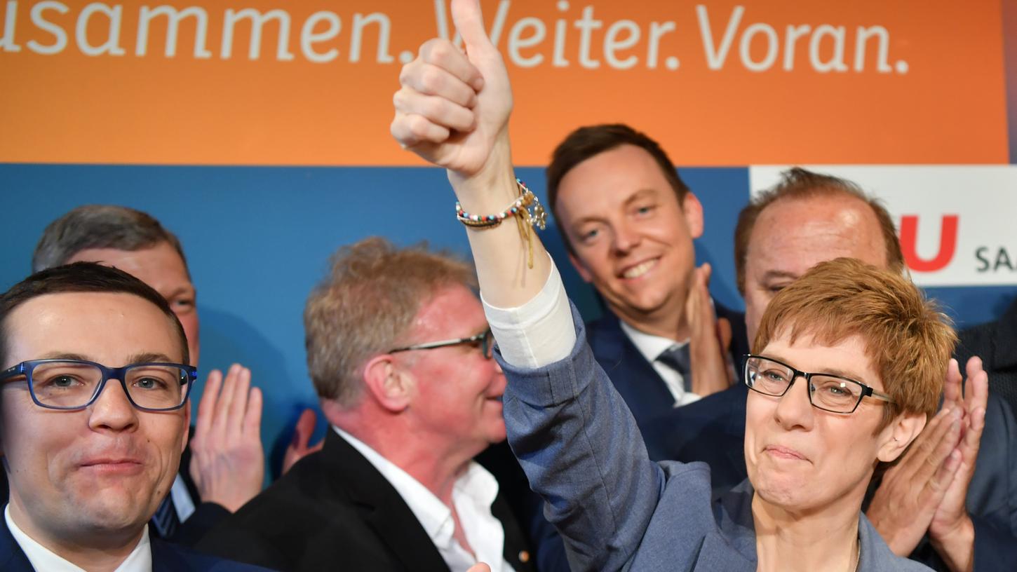 Die saarländische Ministerpräsidentin Annegret Kramp-Karrenbauer (rechts) jubelt auf der CDU-Wahlparty in Saarbrücken ihren Anhängern zu.