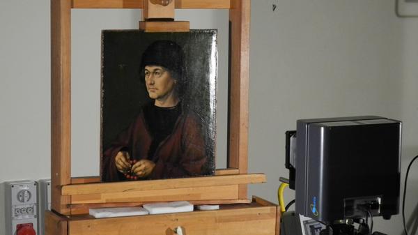 Goldschmied war Albrecht Dürer der Ältere, der Vater des Malers. Bei ihm begann der junge Albercht zunächst eine Lehre als Goldschmied. 1490 malte der Sohn den Vater als Pendant zum Mutter-Bildnis von 1489. Das Vater-Bildnis wird heute in den Uffizien verwahrt. Das Foto entstand im Germanischen Nationalmuseum, wo das Bild vor der großen Dürer-Schau untersucht wurde.